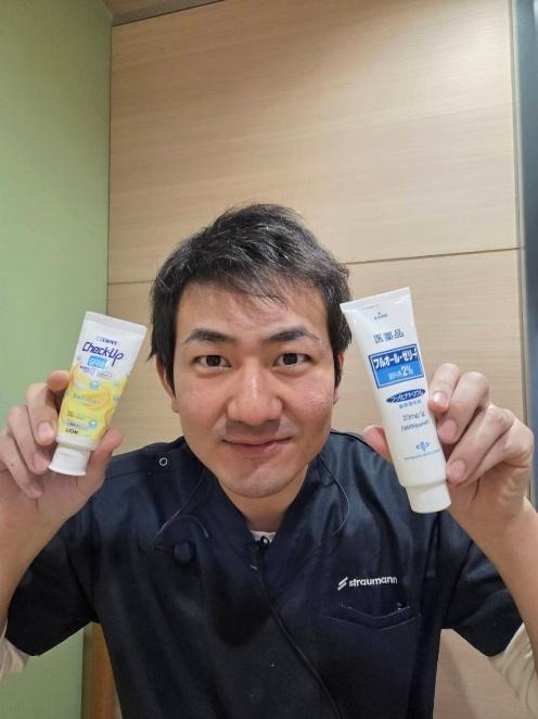 フッ素入りの歯磨き粉を見せる歯科医師