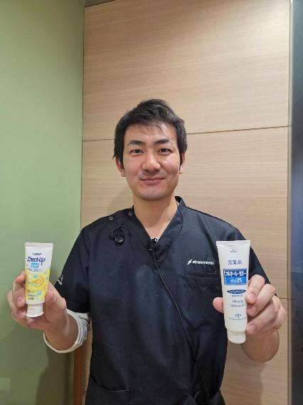 歯磨き粉を持つ歯科医院のスタッフ